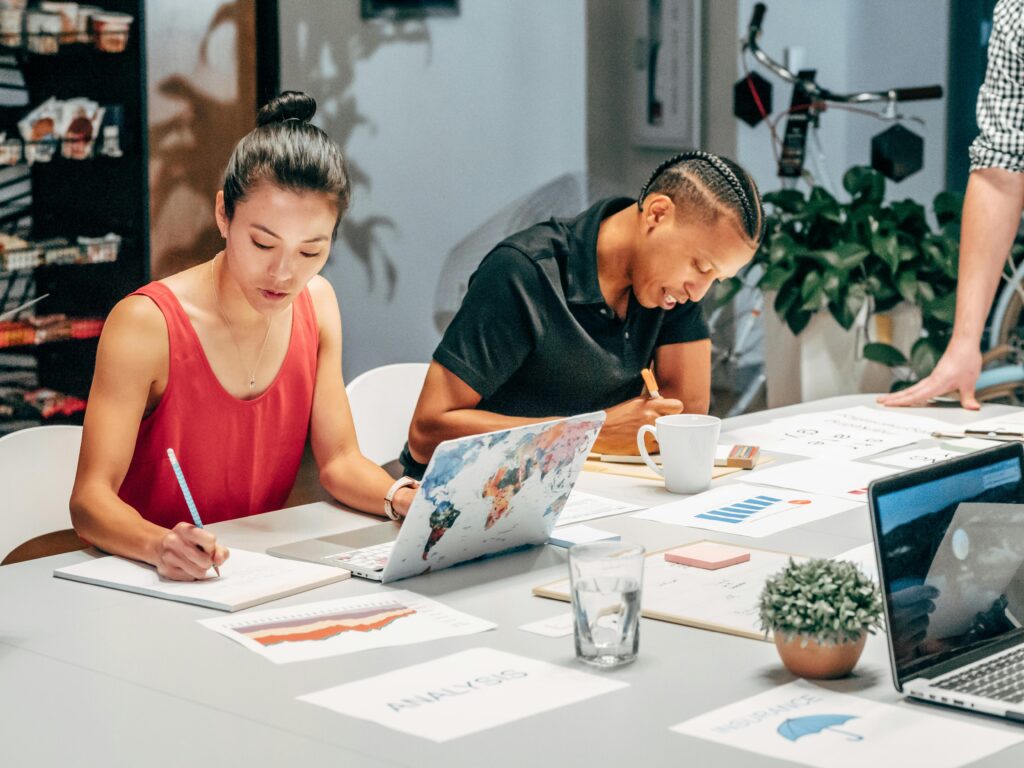 A diverse team engaged in a collaborative office meeting, analyzing data and taking notes.
